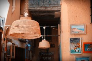 Vista panoramica del borgo di Castelsardo con la rocca e i cestini artigianali in primo piano.