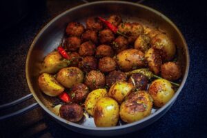 Patate al forno dorate su una teglia antiaderente, pronte per essere servite.